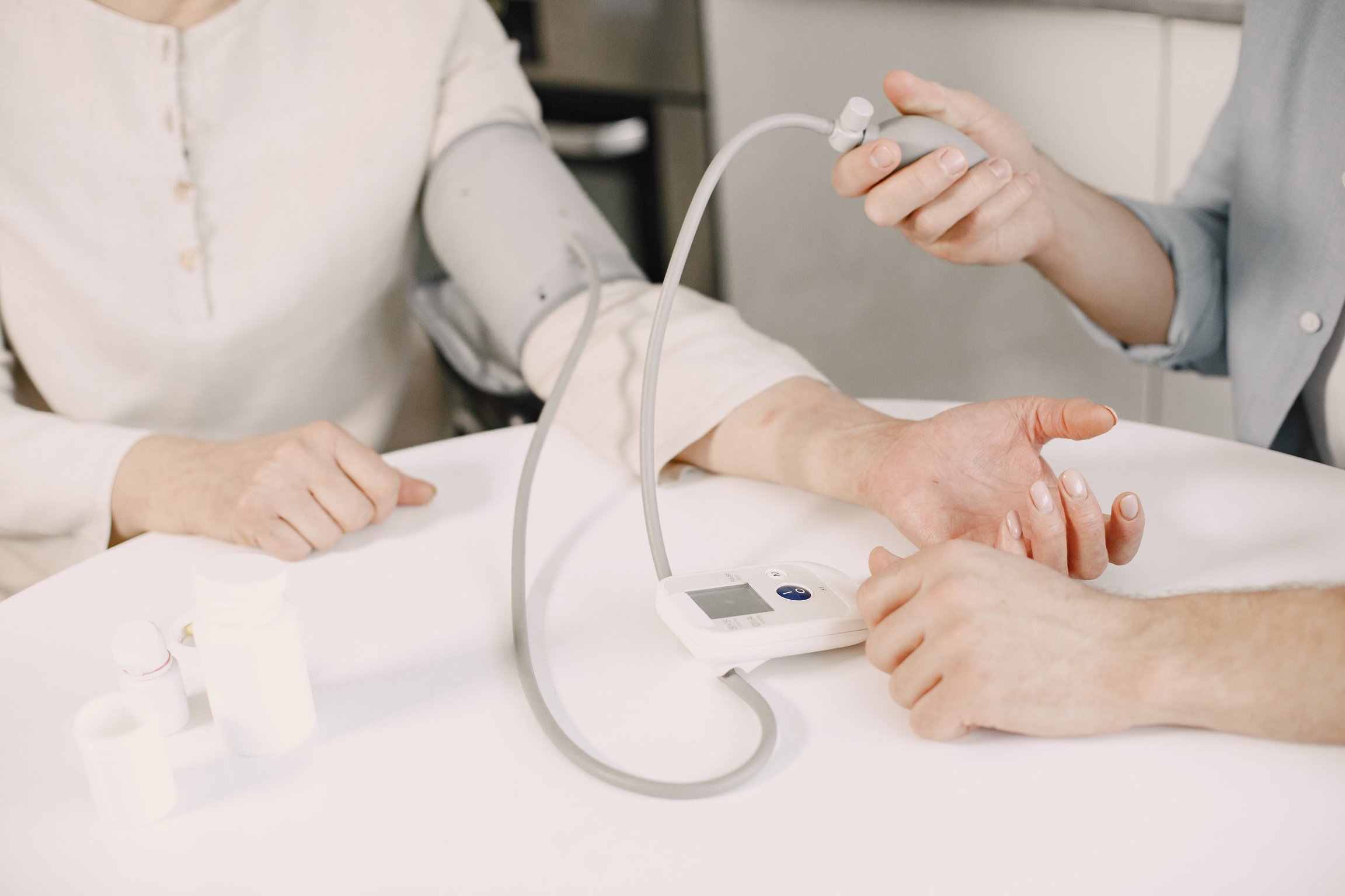 Close-up of Man Measuring Blood Pressure of a Woman Using a Blood Pressure Monitor at Home 